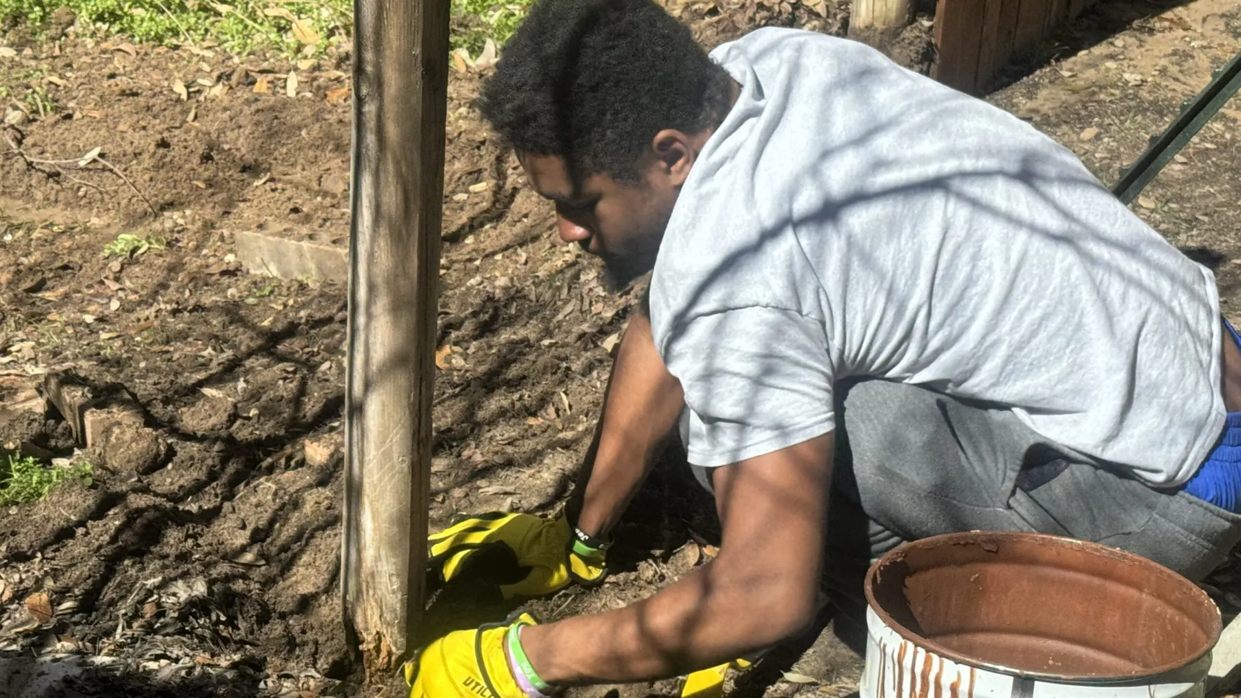 Stain Guys crew member setting a new fence post